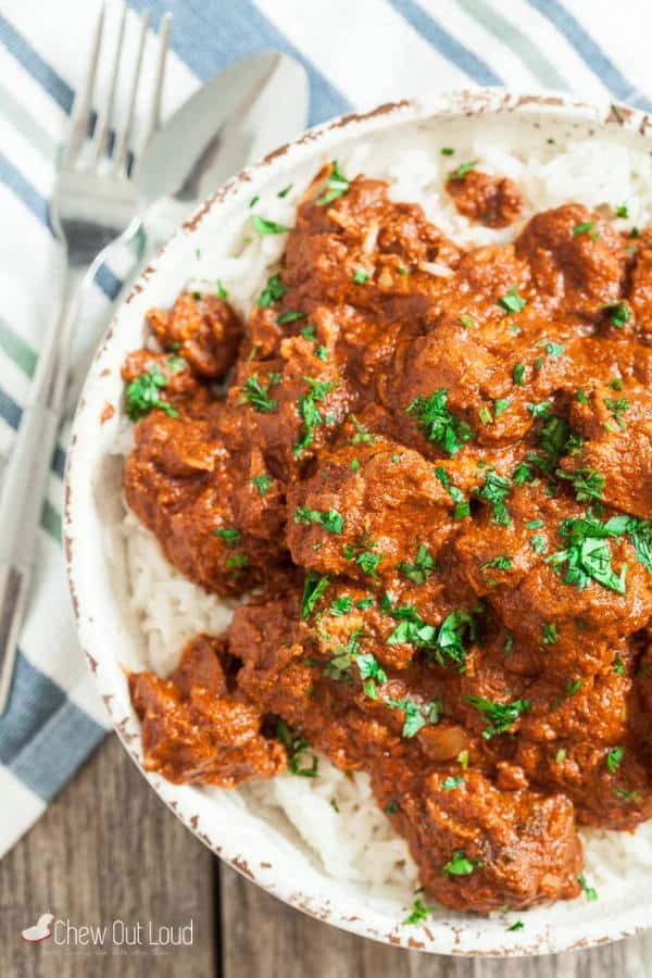 Chicken Tikka Massala served in a white plate next to a fork