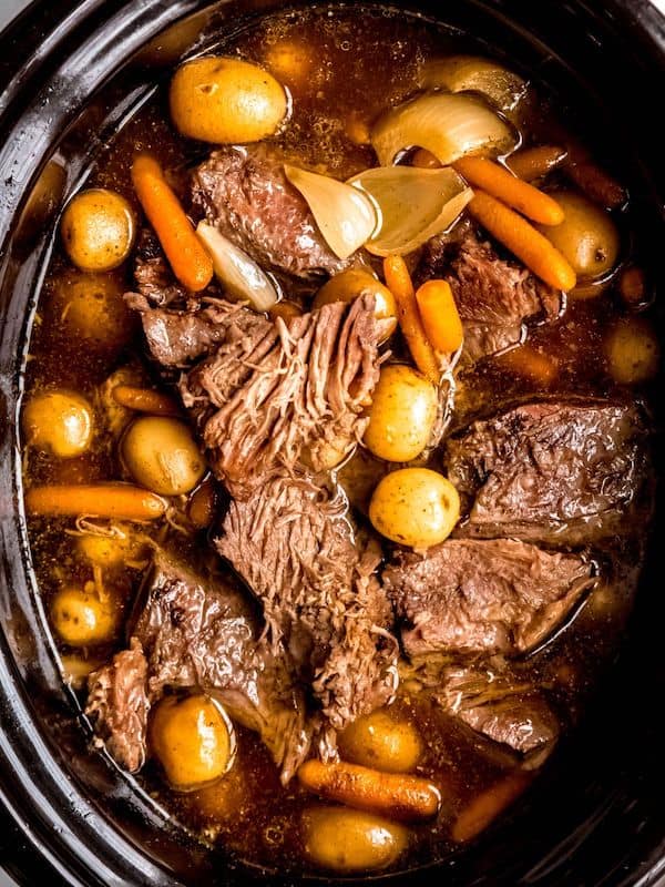 Bottom round rump roast with vegetables in a crockpot.