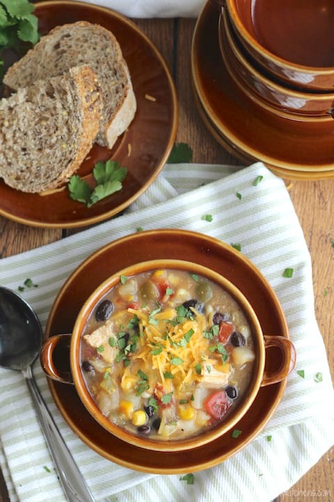 Crock Pot Southwestern Corn Chowder with Chicken and Green Chiles Recipe served on a brown plate next to a piece of bread