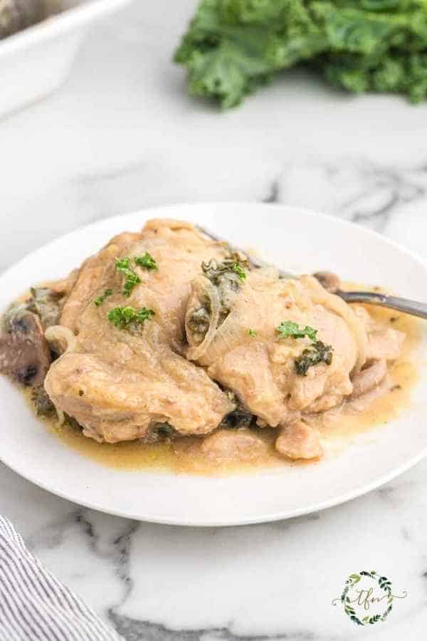 Crockpot smothered chicken served on a white plate