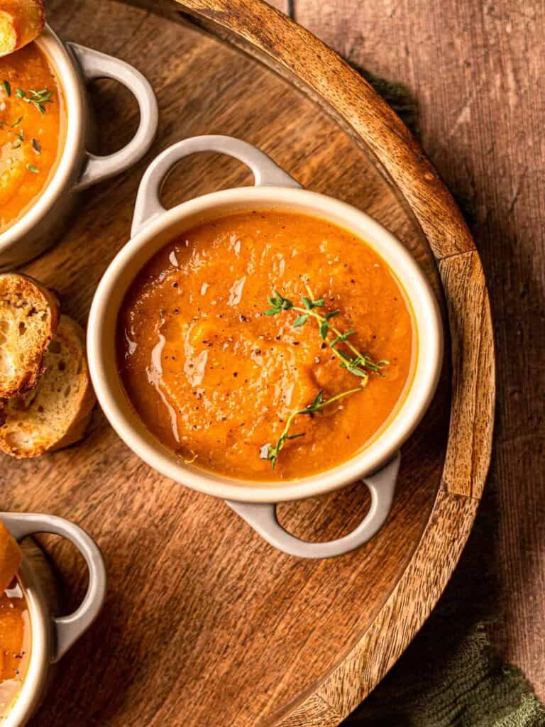 Bowl of pumpkin and sweet potato soup on a tray.