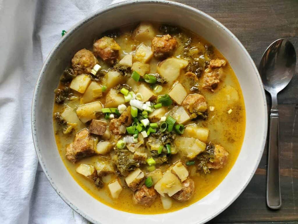 Slow cooker zuppa toscana served on a white bowl.