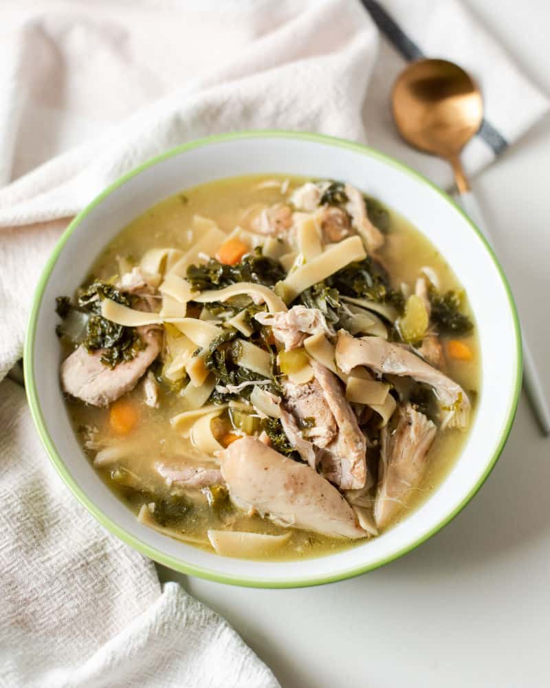 Crockpot Chicken Noodle and Kale Soup in a white bowl