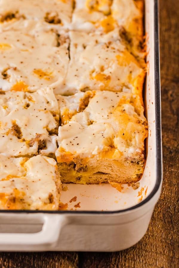 Biscuits and gravy breakfast casserole with sausage and white peppered gravy in a 9×13 dish — a make-ahead Christmas breakfast.