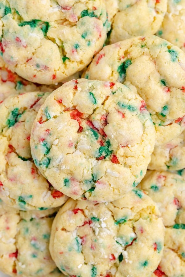 Melt-in-your-mouth Christmas gooey butter cookies rolled in powdered sugar and speckled with red and green sprinkles, arranged on a holiday platter.