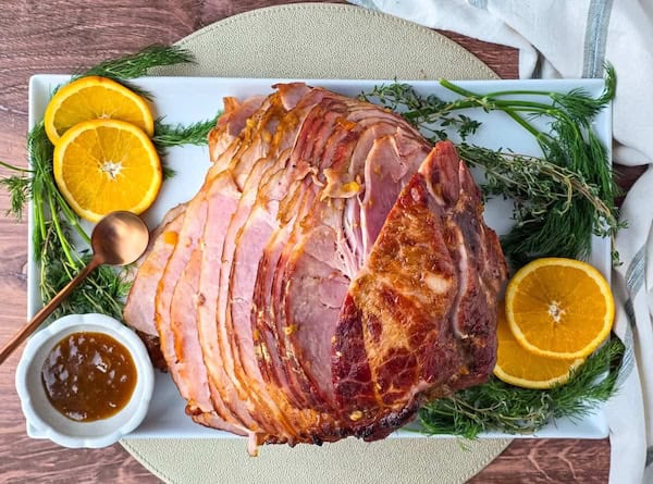 Juicy baked ham brushed with a golden apricot glaze and garnished for Christmas dinner.