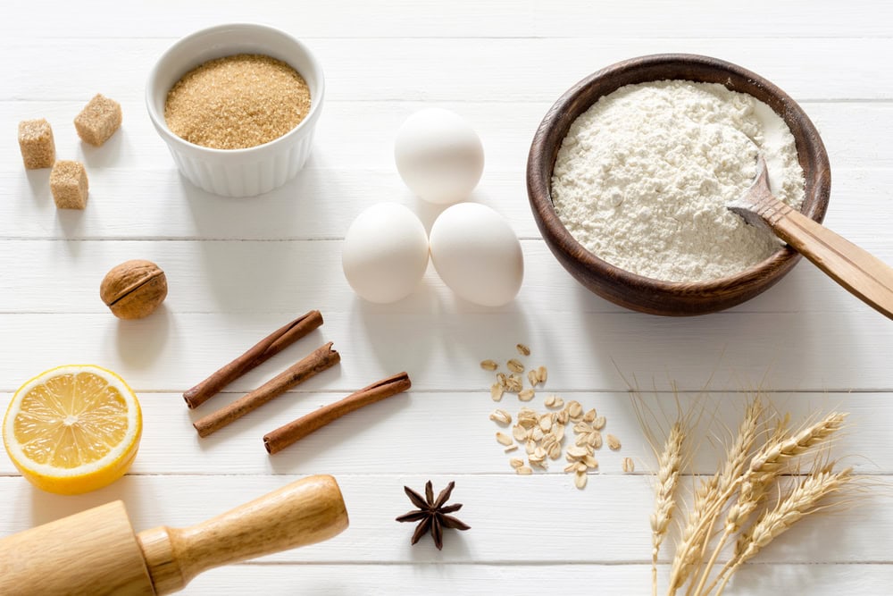 smart cent for life- recipe category image for frugal recipes and cheap budget ideas it shows a bowl with flour, next to three eggs, four cinnamon sticks on a white wooded table