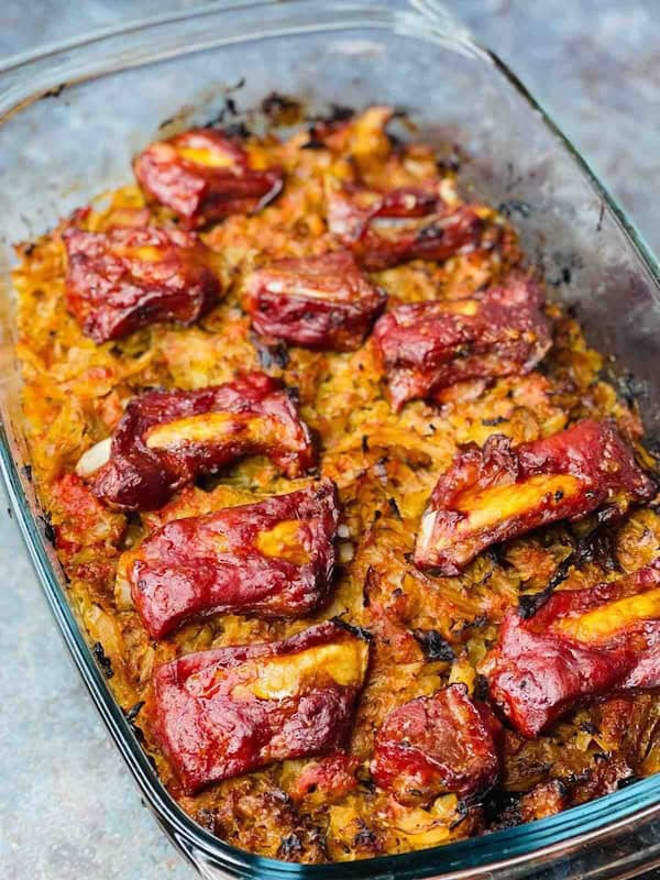 Baked pork ribs and cabbage casserole in a roasting pan — a make-ahead Christmas dinner casserole.