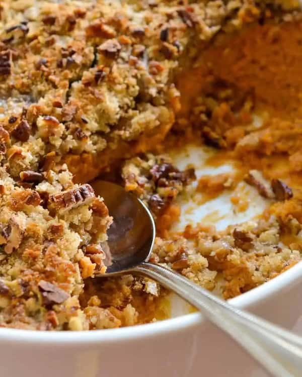 Sweet potato casserole with creamy mashed potatoes and pecan streusel in a round baking dish — a make-ahead Christmas side dish.