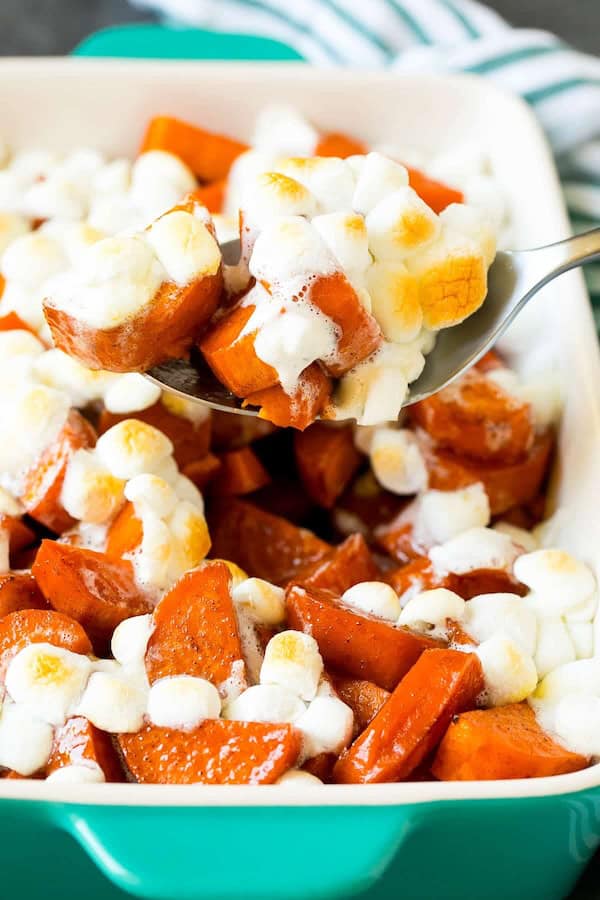 Golden baked candied yams in a white dish glazed with brown sugar and cinnamon — a comforting easy Christmas side dish.

