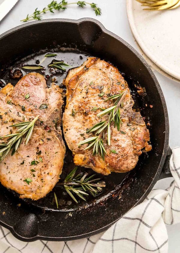 Juicy cast iron pork chops seared with garlic and herbs for an easy Christmas dinner.