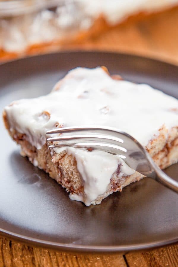 Cinnamon roll French toast casserole topped with cream-cheese icing in a white baking dish — an easy make-ahead Christmas breakfast.