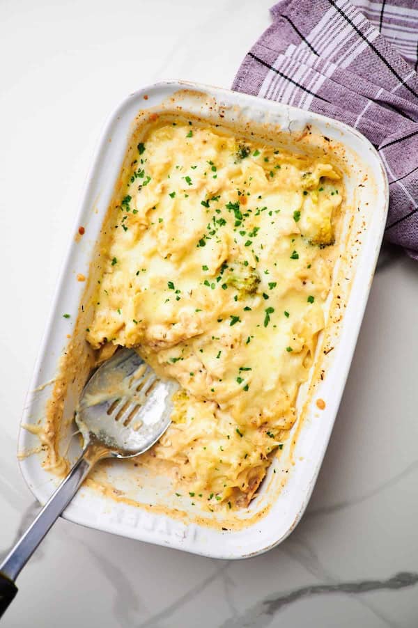 Creamy chicken Alfredo casserole in a baking dish with melted cheese on top — a make-ahead Christmas dinner casserole.