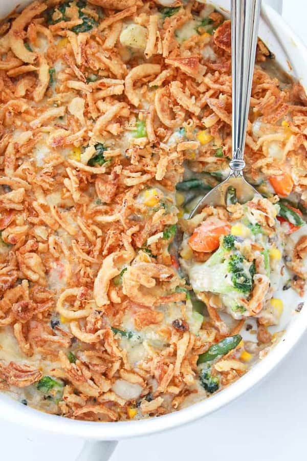 Frozen mixed vegetable casserole with broccoli, cauliflower and crispy onion topping in a baking dish — a make-ahead Christmas side dish.