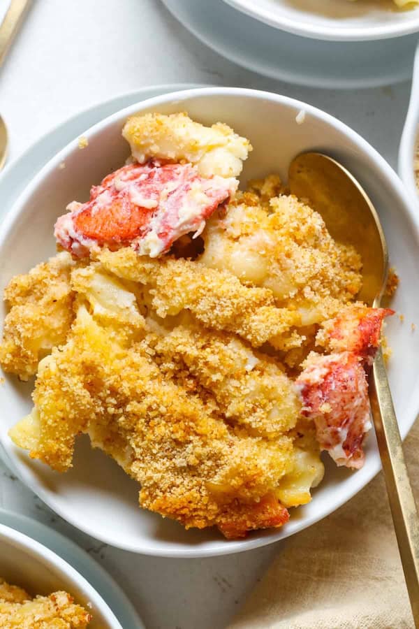 Baked lobster mac and cheese in a casserole dish topped with breadcrumbs and melted cheese, ready for Christmas dinner.