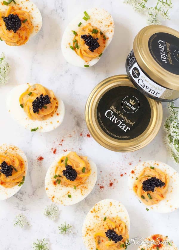 Devilled eggs topped with black caviar on a white serving tray — elegant Christmas appetizer idea.