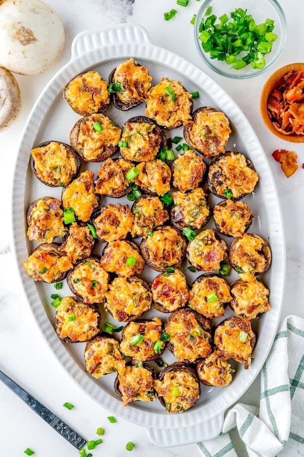 Bacon-stuffed mushrooms baked until golden on a parchment-lined tray — perfect easy holiday appetizer.