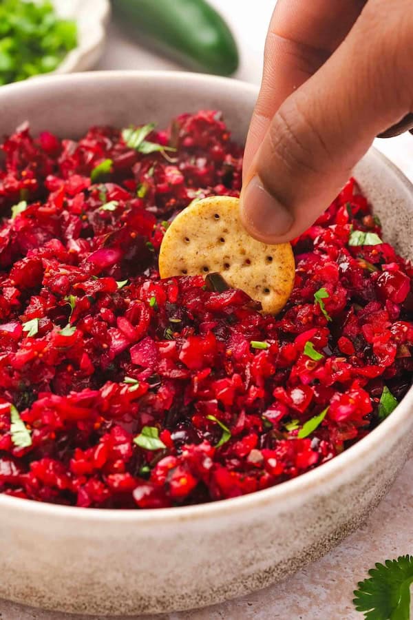 Bowl of cranberry jalapeño salsa in a white bowl - an easy Christmas appetizer idea.