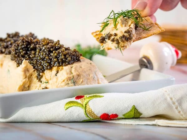 Fluffy dill salmon mousse served in a glass bowl with crackers and lemon wedges for Christmas appetizers.