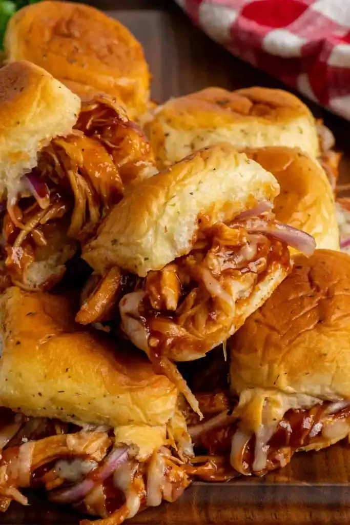 bbq-chicken-sliders-hawaiian-rolls Slow cooked BBQ chicken sliders topped with melted cheese on Hawaiian rolls.
