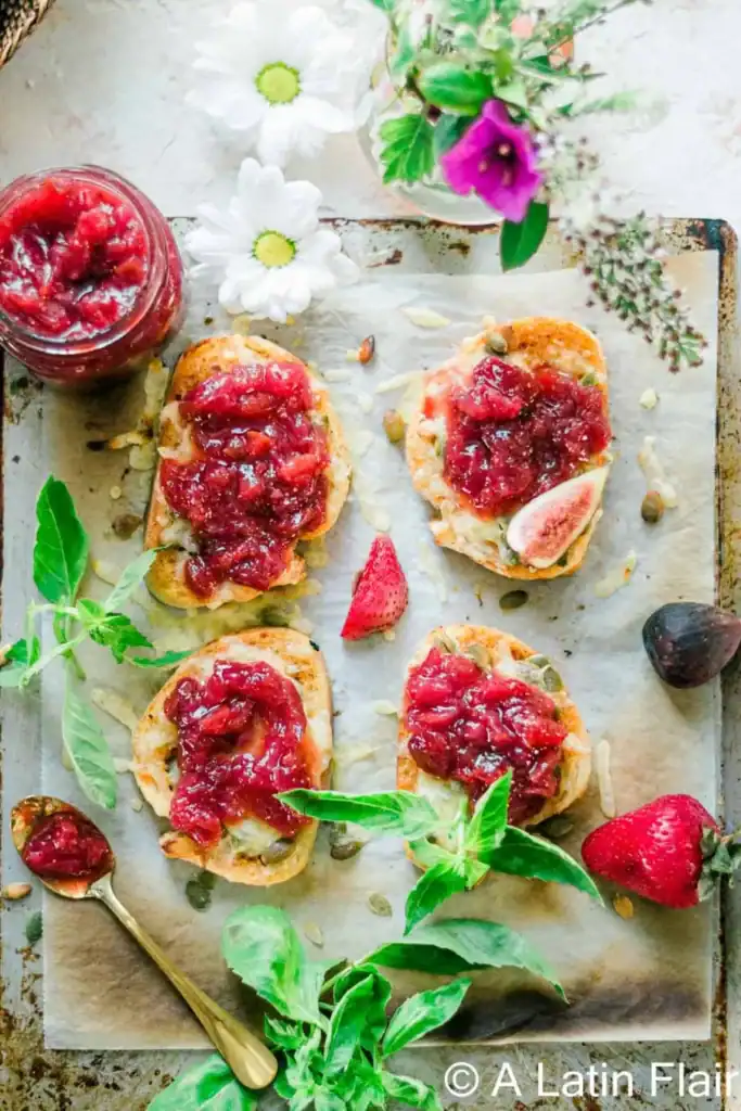 Crostini topped with creamy cheese and strawberry-fig preserves served as an easy New Year’s Eve appetizer.