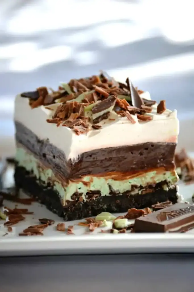 Chocolate mint dream bars with layered pudding, cream, and mint topping in a baking dish