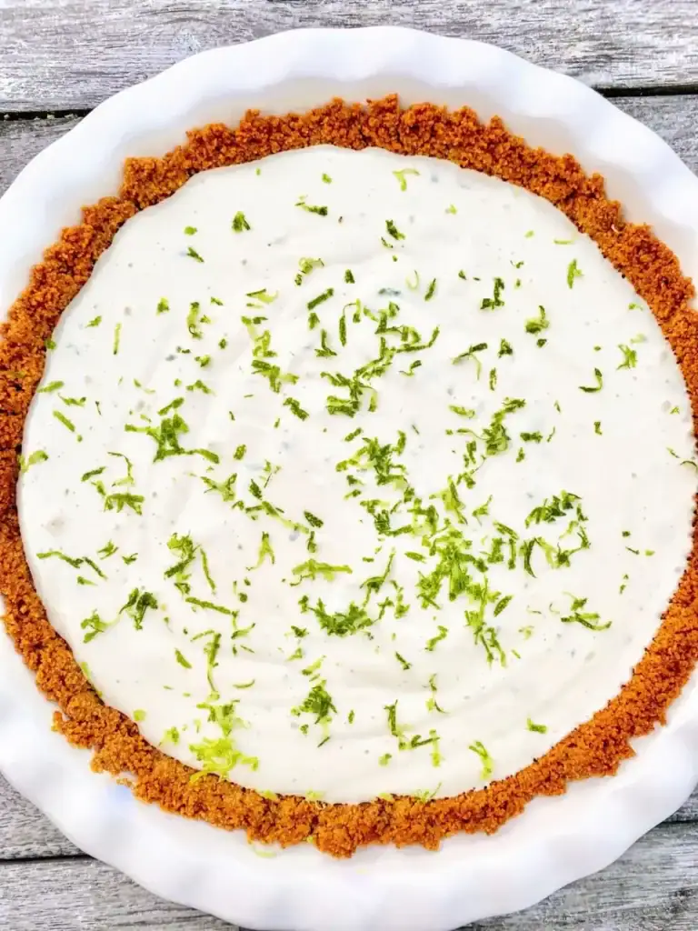 Key lime pie slice with creamy filling and graham cracker crust on a plate