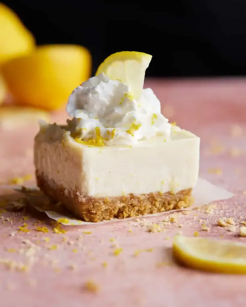 Lemon bars with graham cracker crust dusted with powdered sugar cut into squares