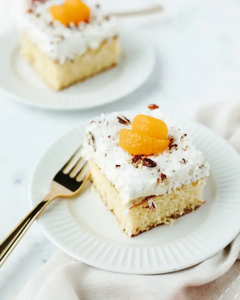 Hawaiian dream cake slice with creamy topping and pineapple texture on a plate