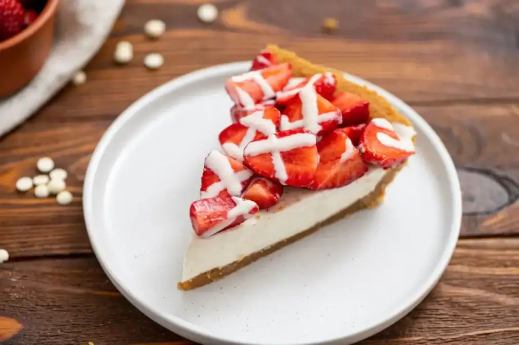 Strawberry white chocolate pie topped with fresh strawberries in a graham cracker crust
